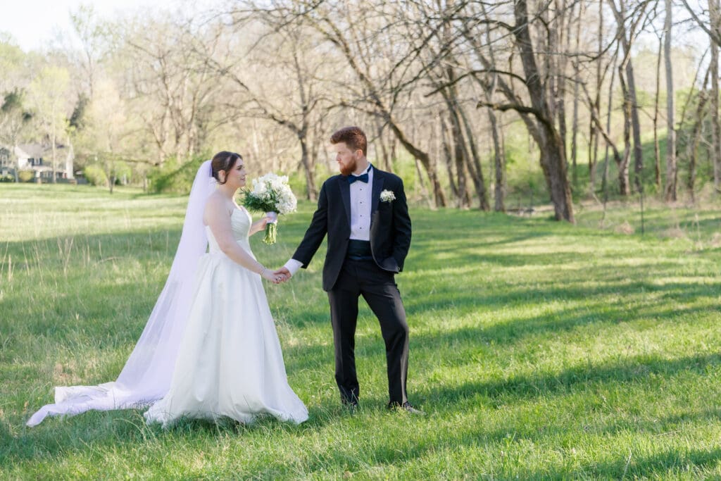 Bride and Groom posing in a green field