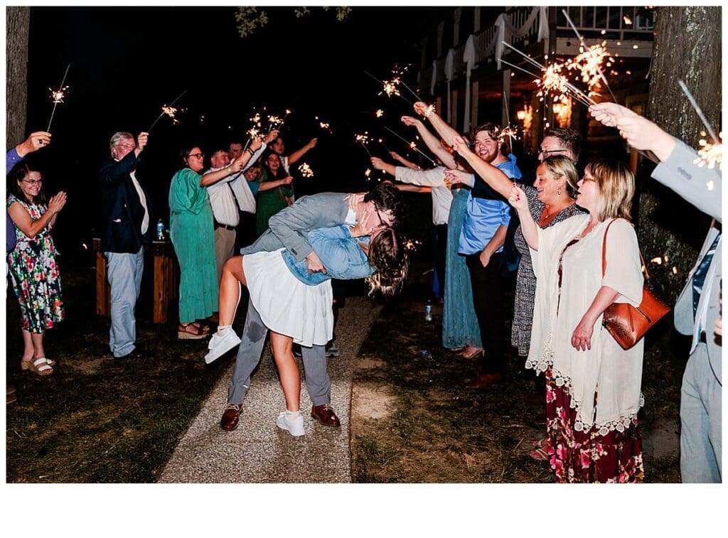 Groom dipped bride for a kiss during their sparkler exit