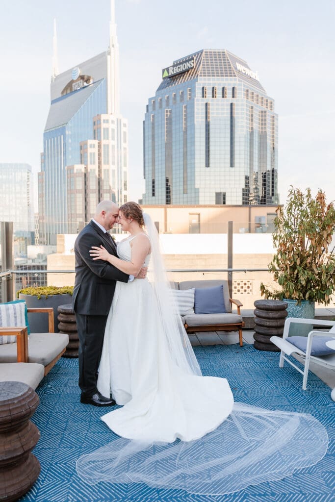 Rooftop wedding portraits of bride and groom with the batman building in the background
