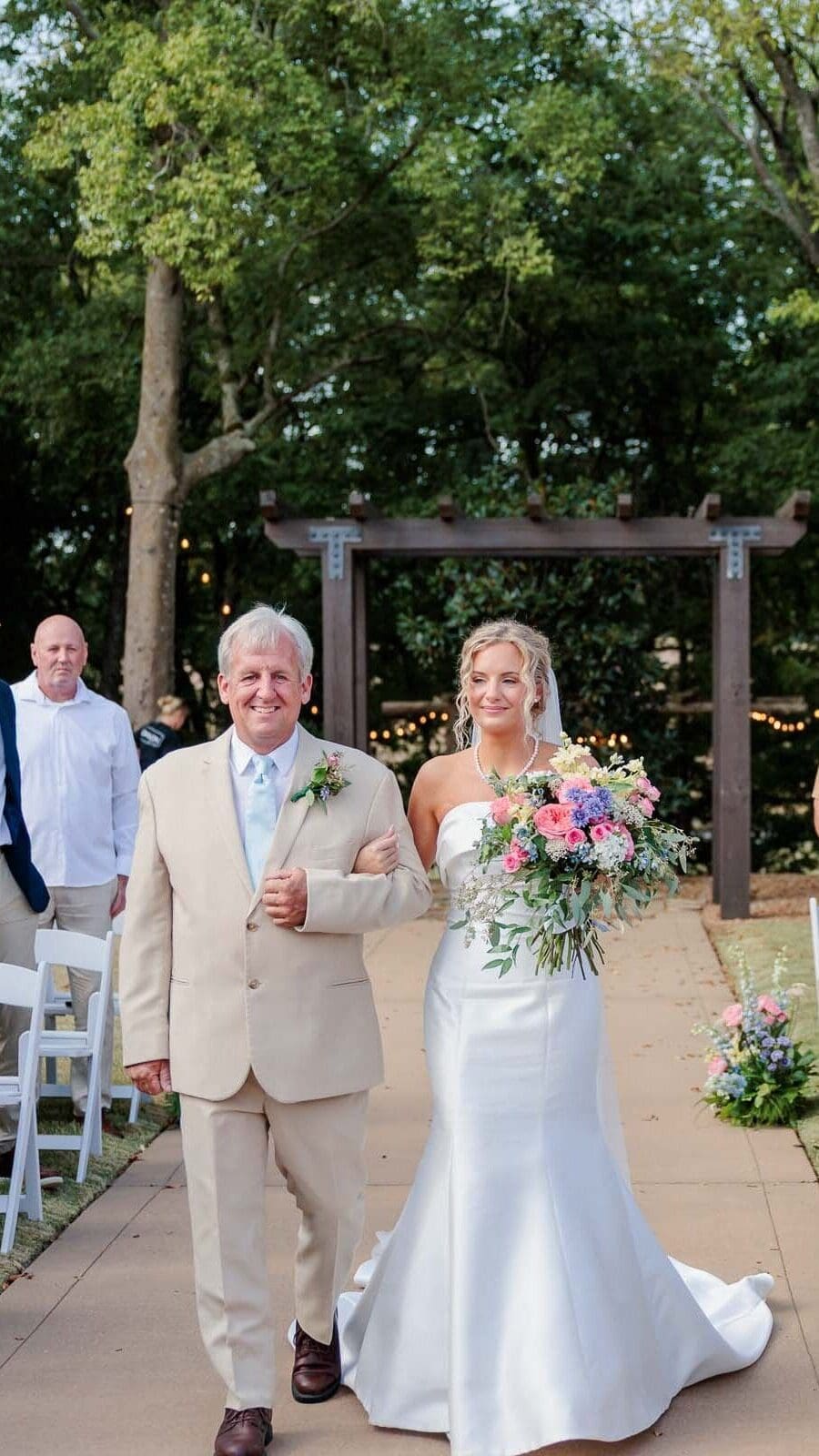Claire walking down the ceremony aisle with her daddy.
