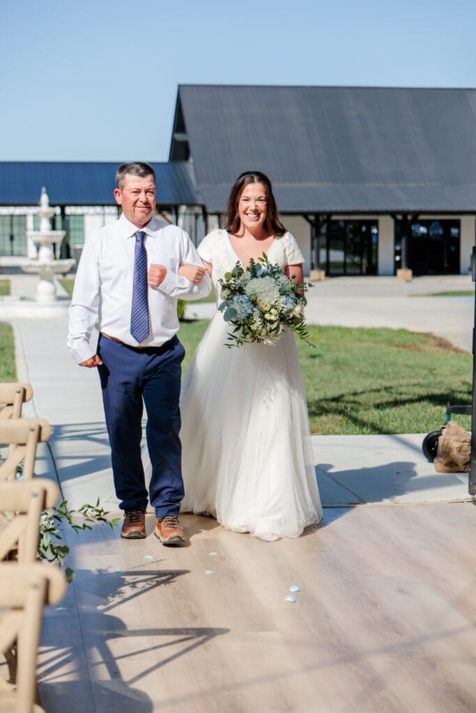 Bride being escorted down the aisle at Jubilee Woods