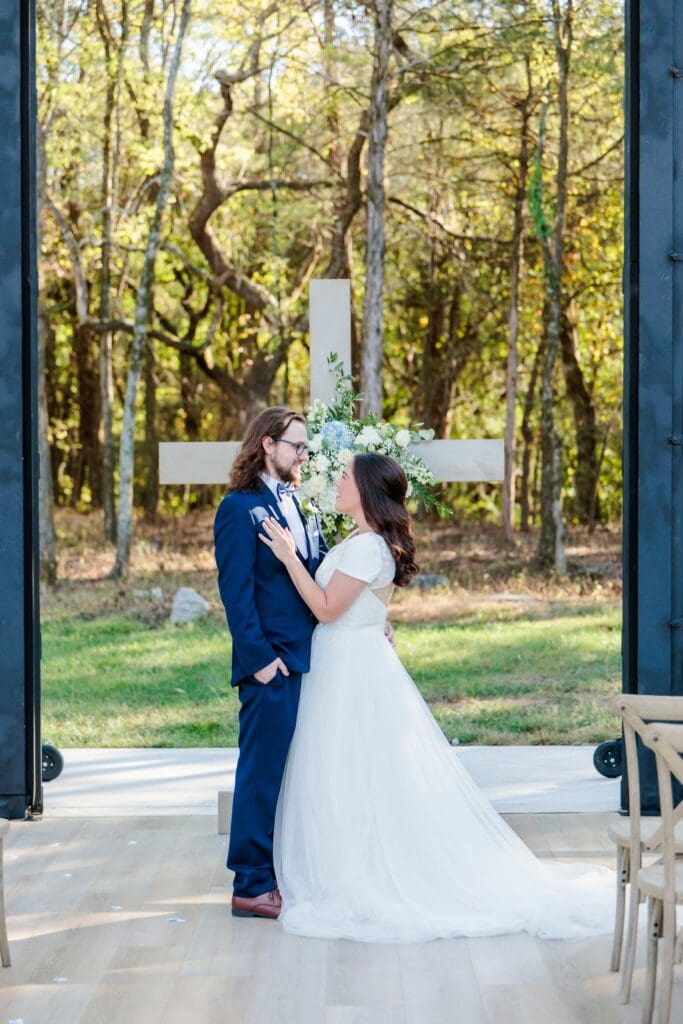 Bride and groom inside glass chapel at Jubilee Woods