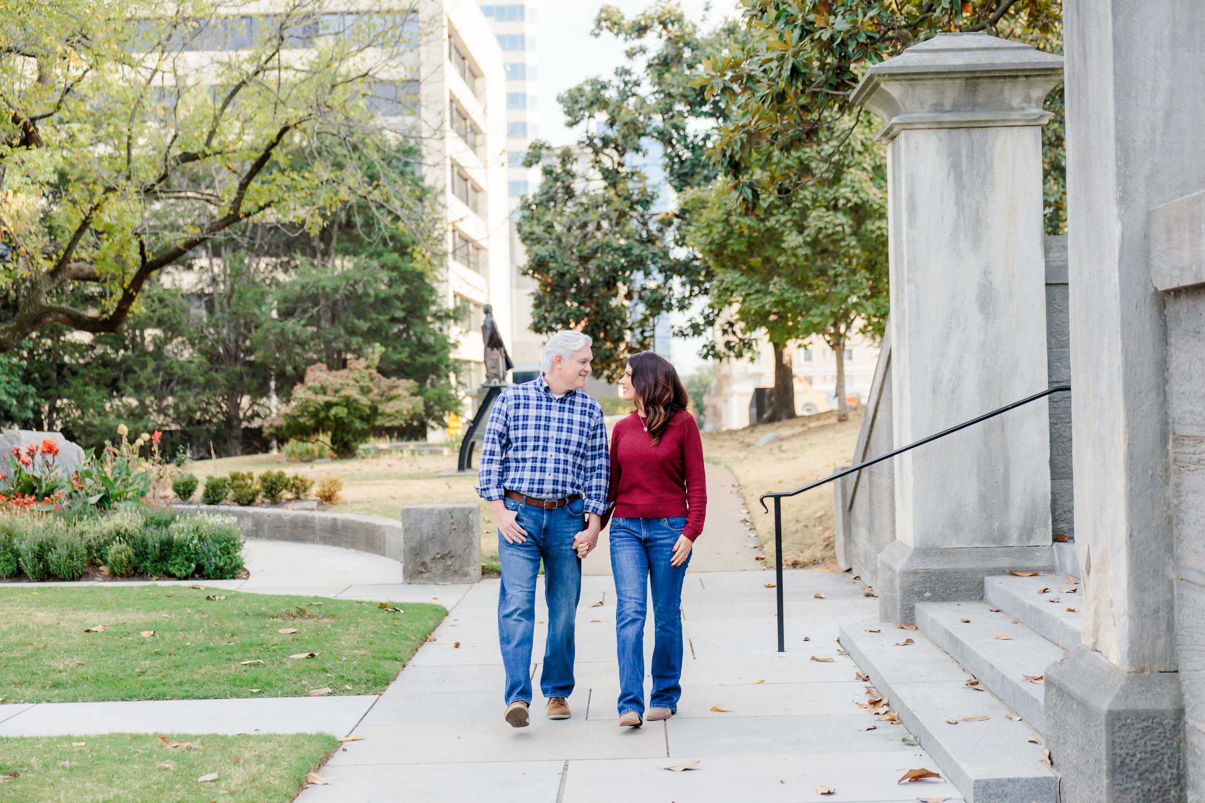 A couple strolling in a park in downtown Nashville for their engagement photos