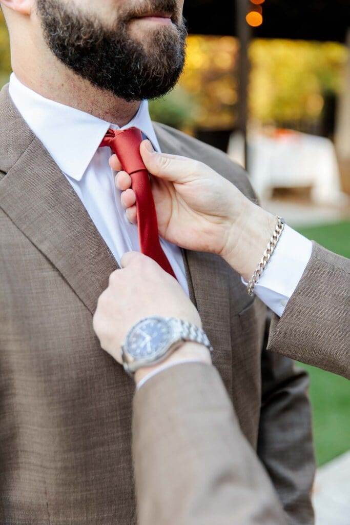 Best man adjusting groom's tie