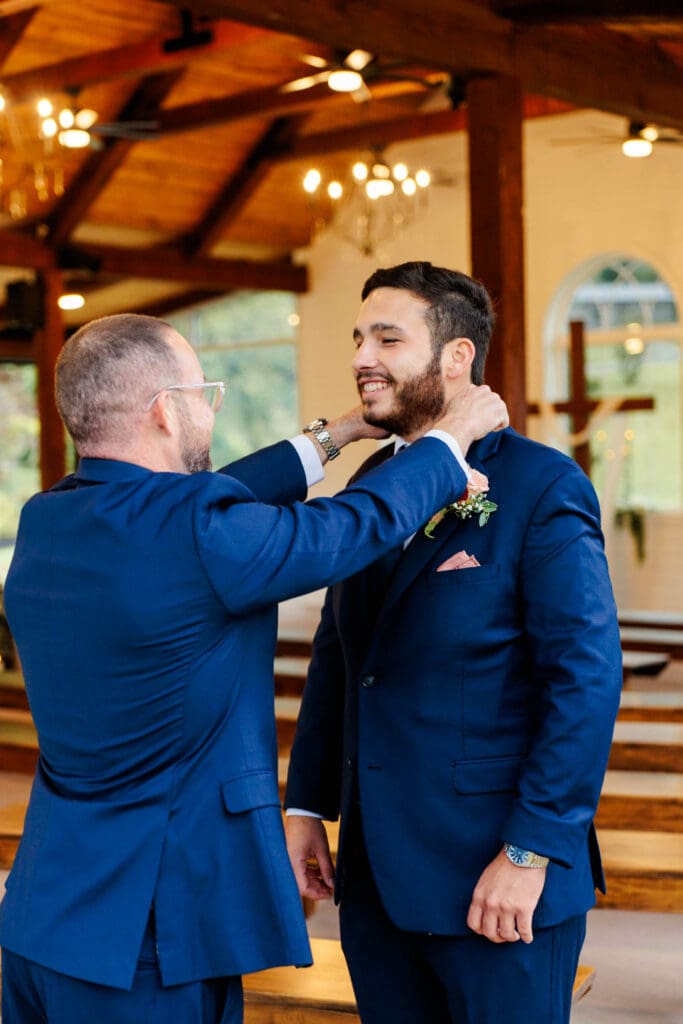 groom getting dressed with the help of his best man.