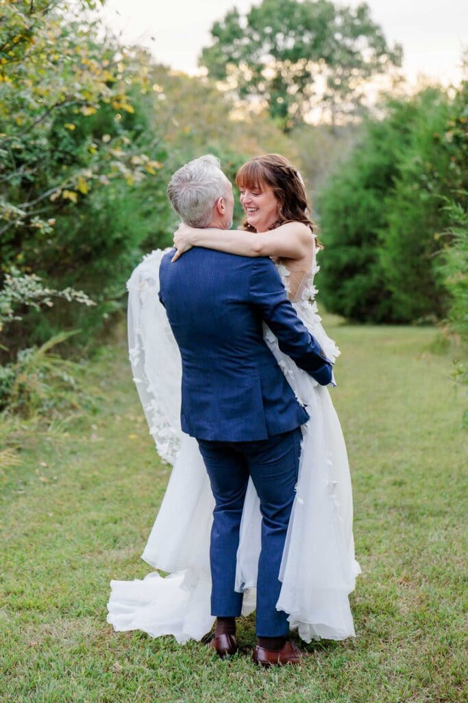 Groom holding bride during just married portraits at Iriswoods wedding and events in Mt. Juliet, TN