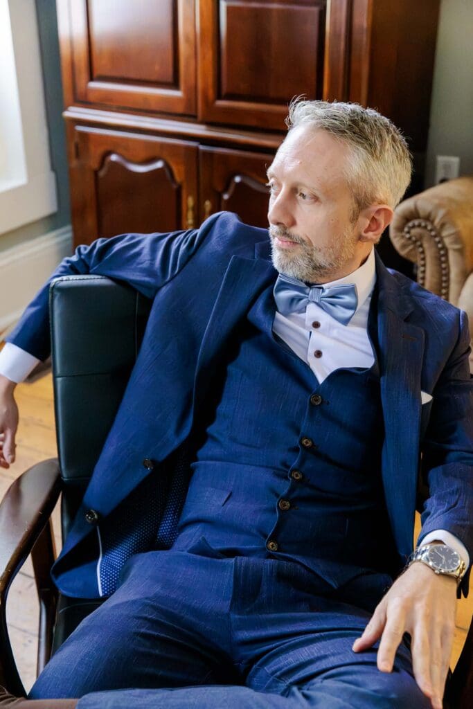 Groom posing in chair at Iriswoods wedding venue near Nashviile, TN