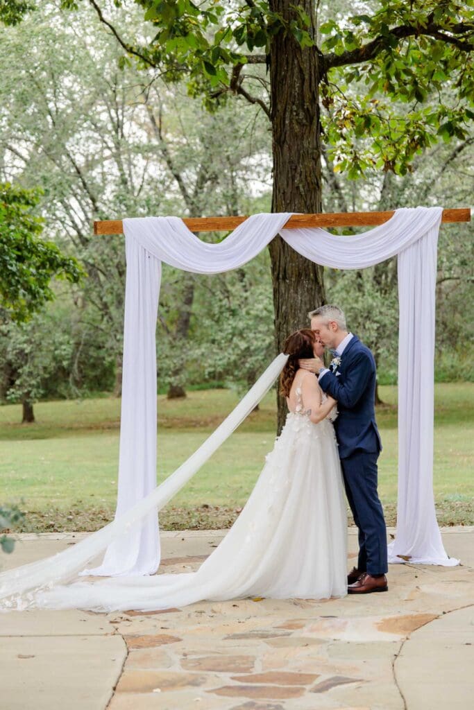 Bride and groom sharing their first kiss as husband and wife at Iriswoods in Mt. Juliet, Tennessee
