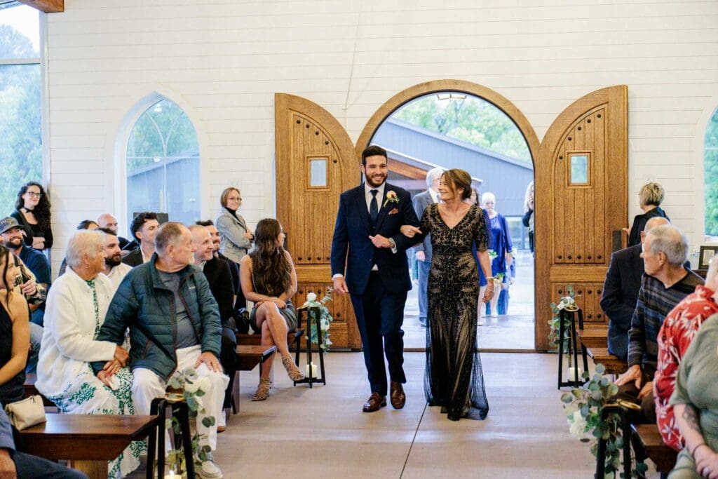 Groom walking down aisle with mom in chapel at Paradise Ranch in Springfield, Tennessee.